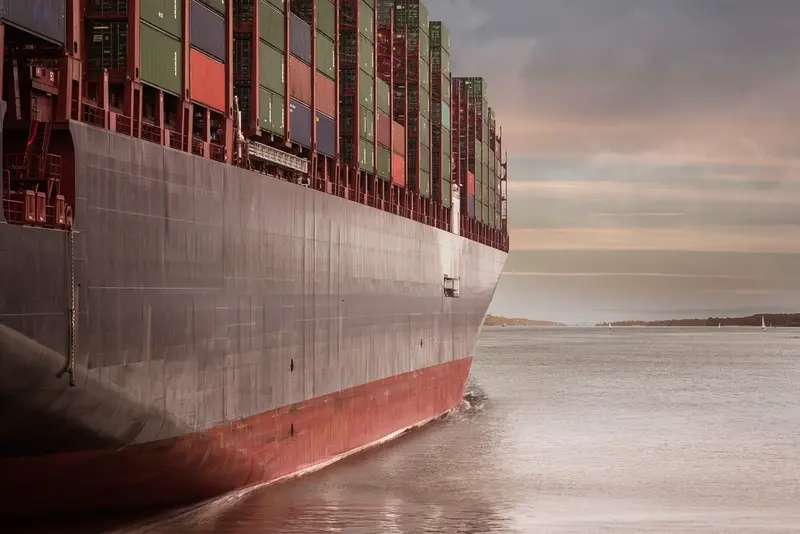 Hull of a loaded container ship at dusk